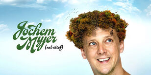 Een bewerkte foto van Jochem Myjer waarop zijn haar een grote bos bomen is, waar vogels boven vliegen. Op zijn voorhoofd loopt een klein hertje.