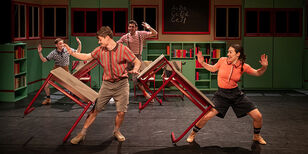  Vier acrobaten dollen in een klaslokaal met de tafeltjes.