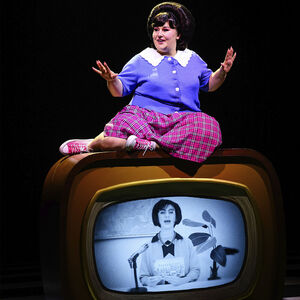 Tracy Turnblad zit bovenop een ouderwetse televisie
