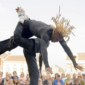 Twee hiphop dansers vliegen acrobatisch door de lucht.