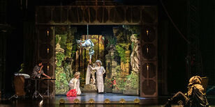 Baroktheatertje in het decor. Vormgegeven met veel pilaren, standbeelden en planten.