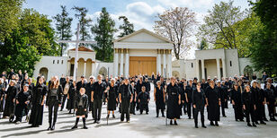 Wel 200 in het zwart geklede spelers en zangers van de Passiespelen staan op het grote podium voor de Romeinse tempels van het openluchttheater in Tegelen.