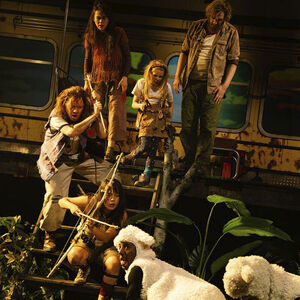 Het gezin Fantastic met ekele schapen. De mensen zien er ruig uit en zijn lang niet bij de kapper geweest.