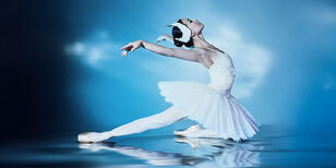 Ballerina in witte tutu in zwanen pose