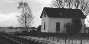 zwartwit foto van een huis langs spoorbaan