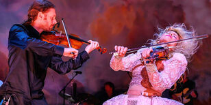 Een uitbundig viool spelende Ellen ten Damme samen met een violist
