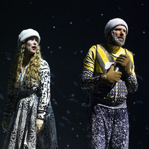 Tegen een donkere sterrenhemel  staan een man en vrouw geschokt te kijken. Ze dragen  winterkleding en dikke wollen mutsen