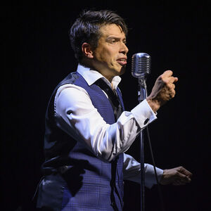 Sjors van der Panne als Jacques Brel. Hij zingt in een grote microfoon. 