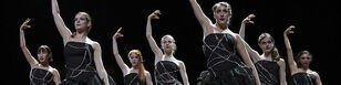 Zeven danseressen gekleed in zwarte tops versierd met metalen kettingen