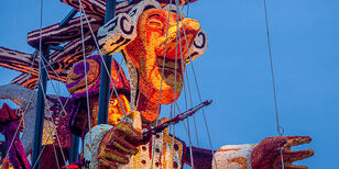 corsowagen met figuur van een dirigent, versierd met duizenden kleurrijke dahliabloemen